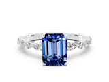 White gold Emerald Cut Blue Sapphire Solitaire with Side Stones on a Pavé Band and Four-Prong Setting