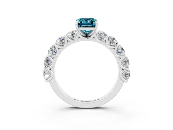 Platinum Emerald Cut Blue Topaz Prong Setting with Side Stones on a Pave Band