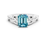 White gold Emerald Cut Blue Topaz Solitaire Engagement Ring with Celtic Knot Band and Four-Prong Setting
