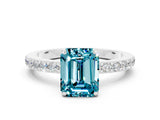 White gold Emerald Cut Blue Topaz Solitaire Engagement Ring with Pavé Band and Four-Prong Setting