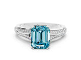 White gold Emerald Cut Blue Topaz Split Shank Engagement Ring with Pavé Band