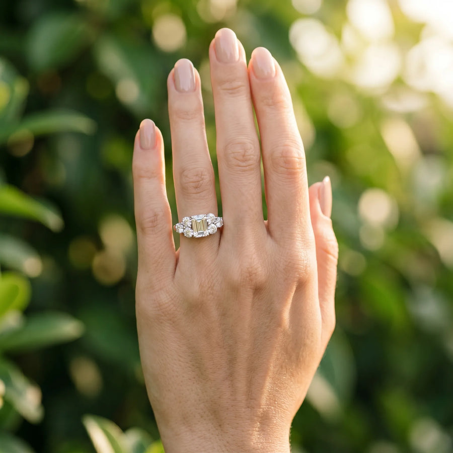 White gold Emerald Cut Diamond Cluster Ring with Round Accent Stones and Prong Setting on a Classic Band
