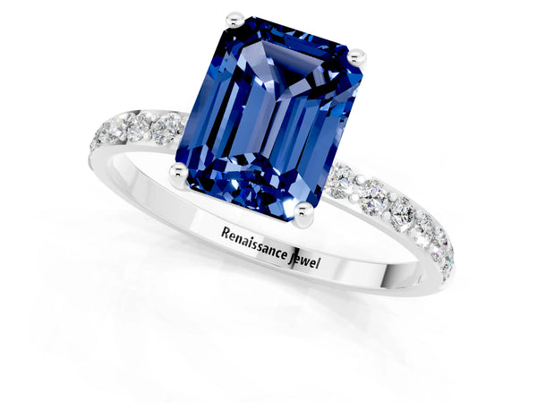 Platinum Emerald Cut Blue Sapphire Solitaire Ring with Round Pavé Shoulders and Prong Setting