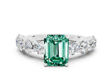 White gold Emerald Cut Green Sapphire Prong Setting with Side Stones on a Pave Band