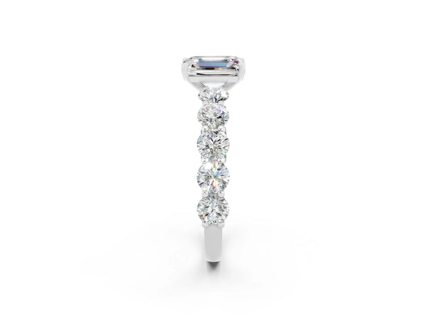 White gold Emerald Cut Moissanite Prong Setting with Side Stones on a Pave Band