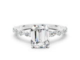 White gold Emerald Cut Moissanite Solitaire with Side Stones on a Pavé Band and Four-Prong Setting