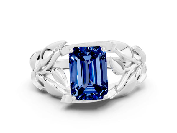 White gold Emerald Cut Blue Sapphire Leaf-Inspired Engagement Ring with Round Accents and Prong Setting