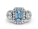 White gold Fancy Blue Emerald Cut Diamond Three-Stone Halo Ring with Prong Setting and Pavé Accents