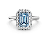 White gold Fancy Blue Emerald Cut Halo Round Diamond Solitaire Ring with Pavé Band and Four-Prong Setting