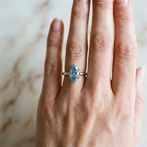Platinum Fancy Blue Marquise Cut Diamond Solitaire Ring with Flower Prong Setting and Classic Band