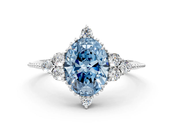 White gold Fancy Blue Oval Cut Brilliant Diamond with Cluster Setting on a Beaded Band and Four-Prong Setting