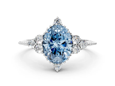 White gold Fancy Blue Oval Cut Brilliant Diamond with Cluster Setting on a Beaded Band and Four-Prong Setting