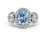 White gold Fancy Blue Oval Cut Diamond Three-Stone Halo Ring with Prong Setting and Pavé Accents