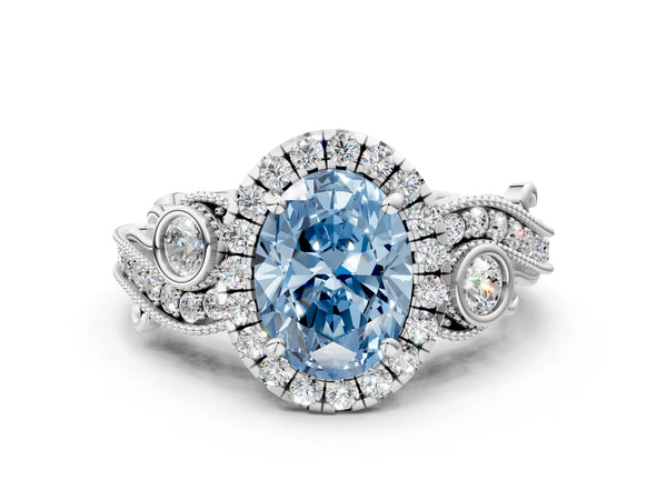 White gold Fancy Blue Oval Cut Halo Diamond Ring with Milgrain and Bezel Accents on a Split Shank Band