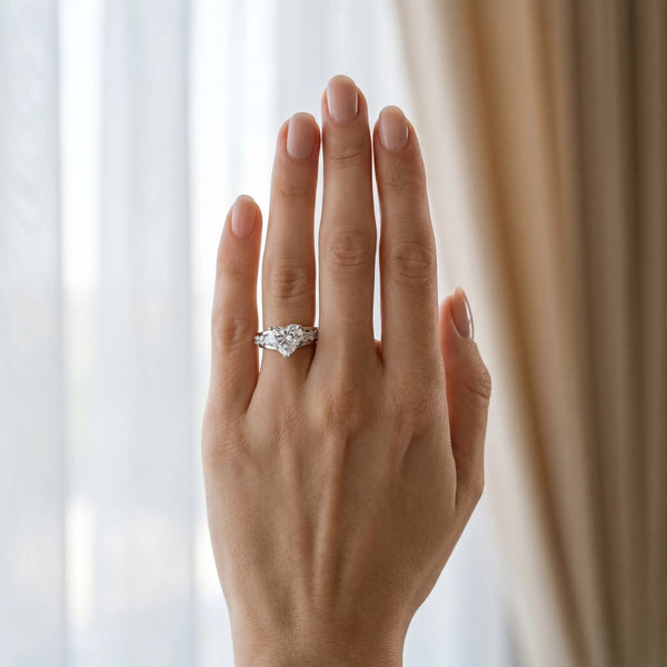 White gold Heart Brilliant Solitaire with Side Stones on a Pave Band and Four-Prong Setting