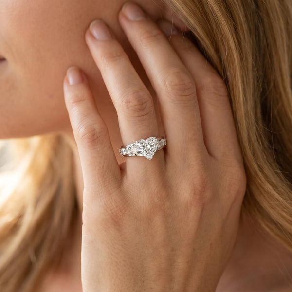 White gold Heart Brilliant Solitaire with Side Stones on a Pave Band and Four-Prong Setting