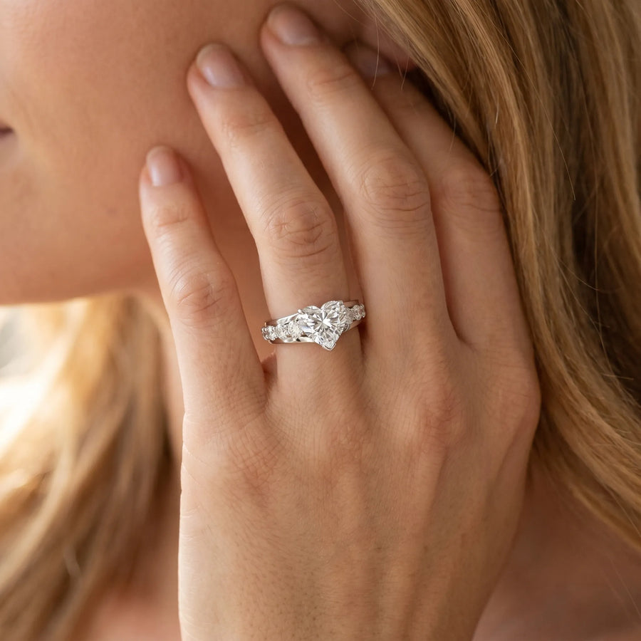 White gold Heart Brilliant Solitaire with Side Stones on a Pave Band and Four-Prong Setting