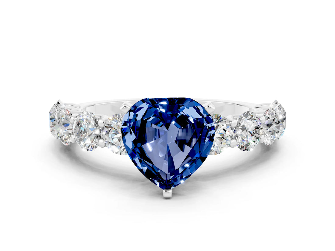 White gold Heart Cut Blue Sapphire Prong Setting with Side Stones on a Pave Band