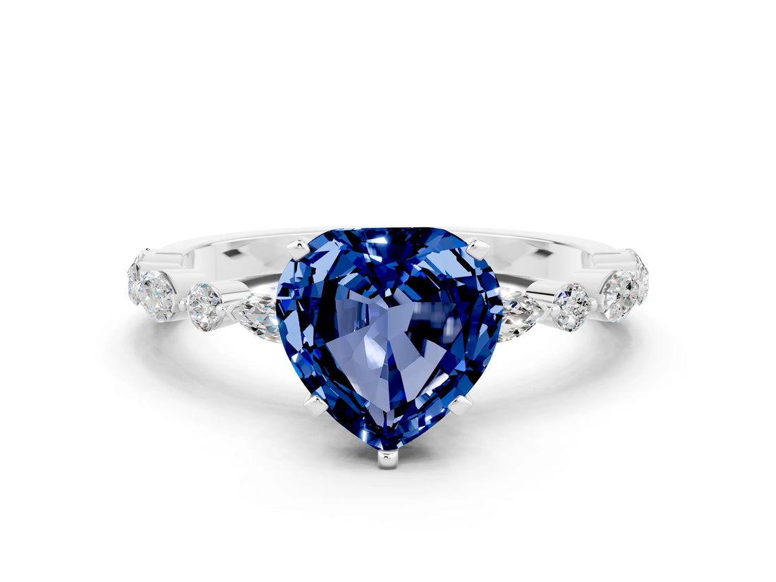 White gold Heart Cut Blue Sapphire Solitaire with Side Stones on a Pavé Band and Four-Prong Setting