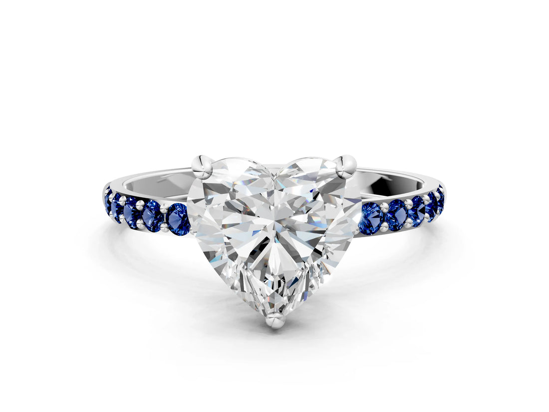 White gold Heart Cut Diamond Solitaire Ring with Round with Blue Sapphire side stone Pavé Band and Prong Setting