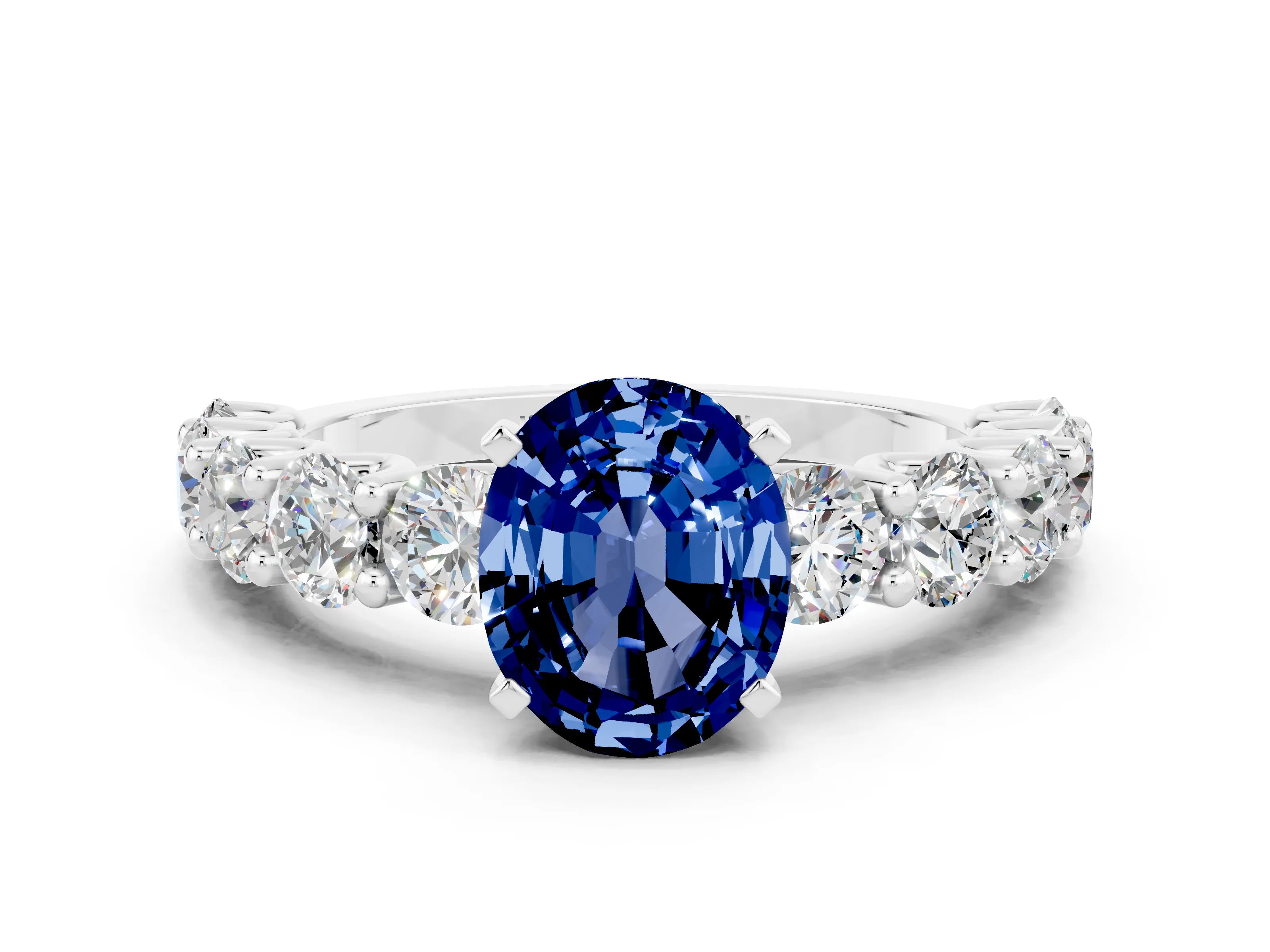 White gold Oval Cut Blue Sapphire Prong Setting with Side Stones on a Pave Band