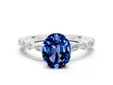 White gold Oval Cut Blue Sapphire Solitaire with Side Stones on a Pavé Band and Four-Prong Setting