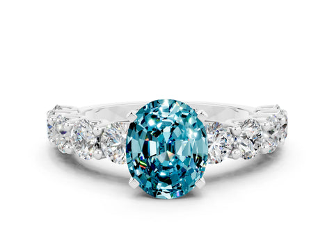White gold Oval Cut Blue Topaz Prong Setting with Side Stones on a Pave Band