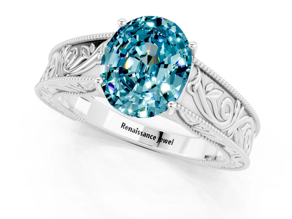 Platinum Oval Cut Blue Topaz Solitaire Ring with Engraved Band and Four-Prong Setting