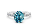 White gold Oval Cut Blue Topaz Solitaire Ring with Pavé Accents and Four-Prong Setting