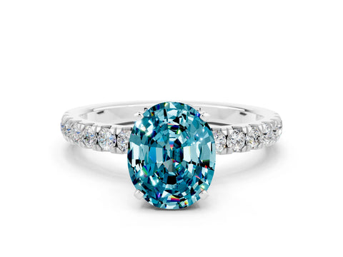 White gold Oval Cut Blue Topaz Solitaire Ring with Pavé Accents and Four-Prong Setting