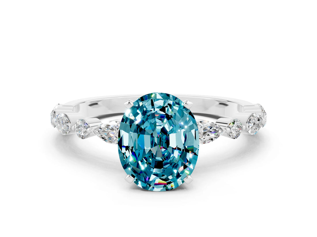 White gold Oval Cut Blue Topaz Solitaire with Side Stones on a Pavé Band and Four-Prong Setting