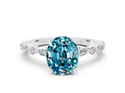 White gold Oval Cut Blue Topaz Solitaire with Side Stones on a Pavé Band and Four-Prong Setting