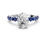 White gold Oval Cut Diamond Side Stone Solitaire Ring with Round with Blue Sapphire side stone and Four-Prong Setting