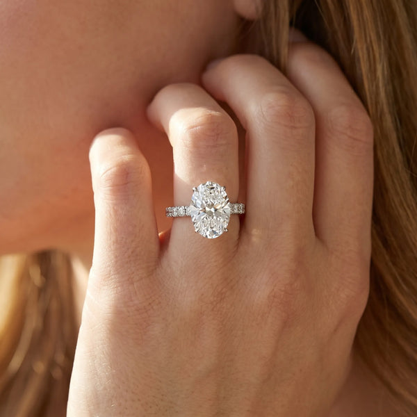 White gold Oval Cut Diamond Solitaire Ring with Pavé Accents and Four-Prong Setting