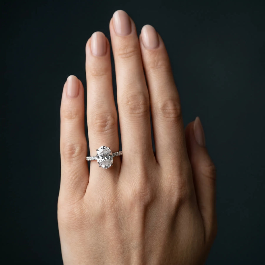 White gold Oval Cut Diamond Solitaire Ring with Pavé Band and Hidden Halo