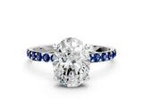 White gold Oval Cut Diamond Solitaire Ring with Round with Blue Sapphire side stone Pavé Band and Prong Setting