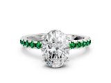 White gold Oval Cut Diamond Solitaire Ring with Round with Emerald side stone Pavé Band and Four-Prong Setting