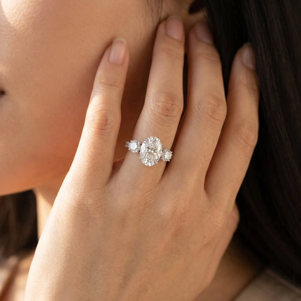 White gold Oval Cut Diamond Three-Stone Ring with Round Side Stones and Pavé Band