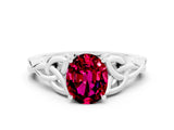 White gold Oval Cut Garnet Solitaire Engagement Ring with Celtic Knot Band and Four-Prong Setting