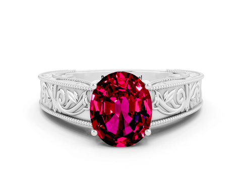 White gold Oval Cut Garnet Solitaire Ring with Engraved Band and Four-Prong Setting