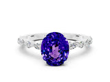 White gold Oval Cut Tanzanite Solitaire with Side Stones on a Pavé Band and Four-Prong Setting