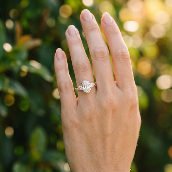 White gold Oval Cut Three-Stone Diamond Ring with Pear Side Stones on a Classic Solitaire Band with Prong Setting