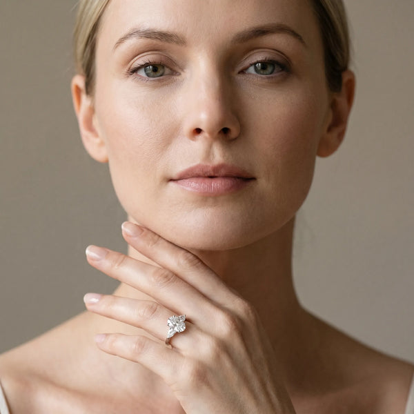White gold Oval Cut Three-Stone Diamond Ring with Pear Side Stones on a Classic Solitaire Band with Prong Setting
