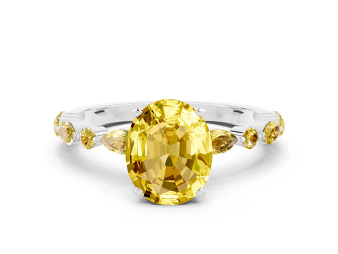 White gold Oval Cut Yellow Sapphire Solitaire with Side Stones on a Pavé Band and Four-Prong Setting