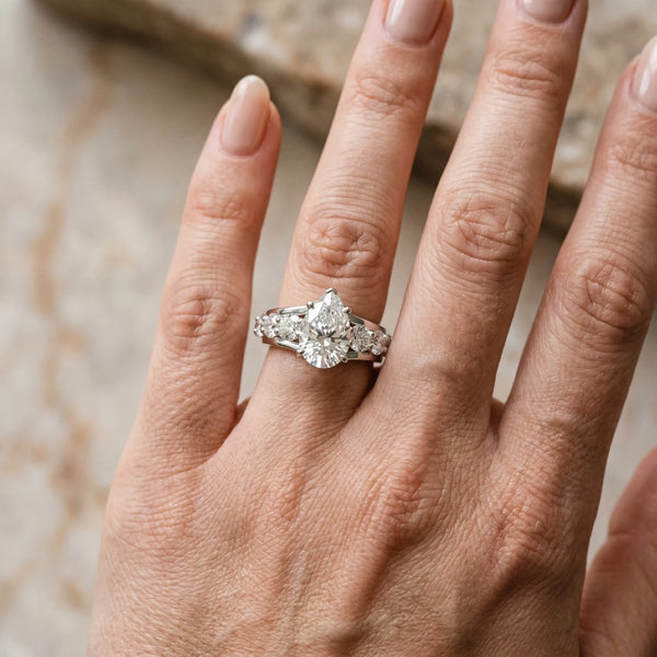 White gold Pear Brilliant Solitaire with Side Stones on a Pave Band and Four-Prong Setting