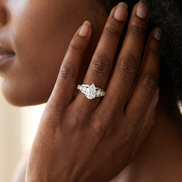 White gold Pear Brilliant Solitaire with Side Stones on a Pave Band and Four-Prong Setting