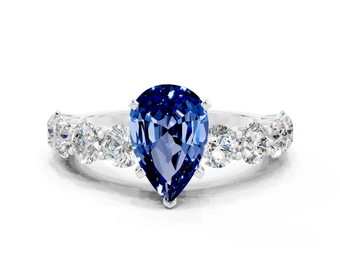 White gold Pear Cut Blue Sapphire Prong Setting with Side Stones on a Pave Band