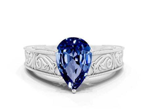 White gold Pear Cut Blue Sapphire Solitaire Ring with Engraved Band and Four-Prong Setting