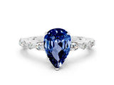 White gold Pear Cut Blue Sapphire Solitaire with Side Stones on a Pavé Band and Four-Prong Setting