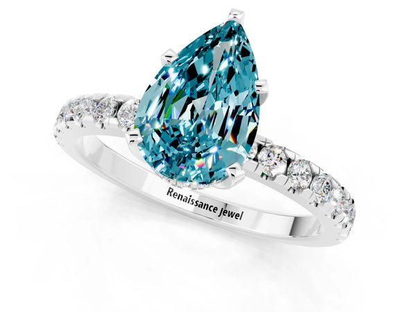White gold Pear Cut Blue Topaz Solitaire Ring with Round Pavé Band and Four-Prong Setting